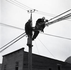 Men up a hydro pole