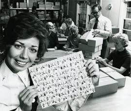 Woman holding "Fight tuberculosis" stamps