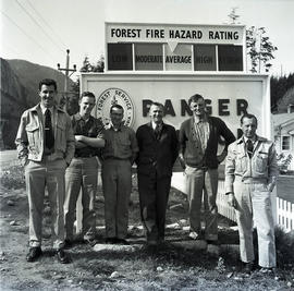 Group of men with Forest Service ranger sign