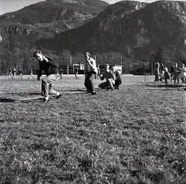 People in field beside football match