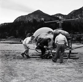 Men doing something to helicopter