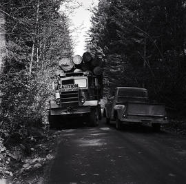 Small truck passing logging truck