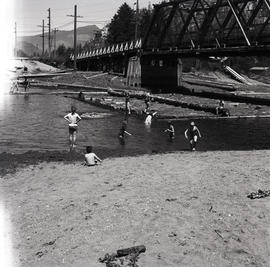 People at beach by bridge