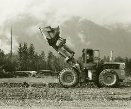 Tractor and airplane in field